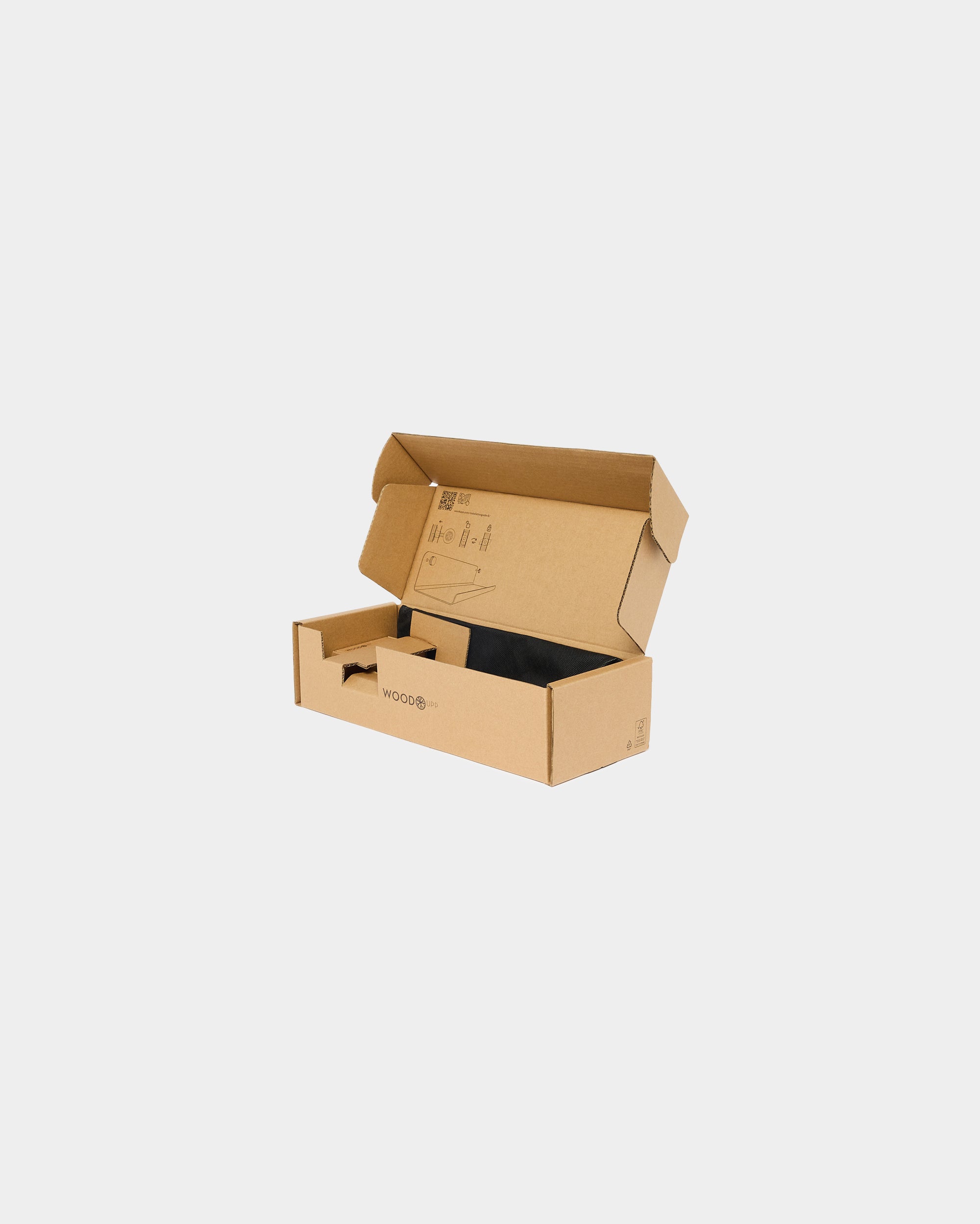 Open brown cardboard box containing a partially visible black acoustic panel, placed on a plain white background.